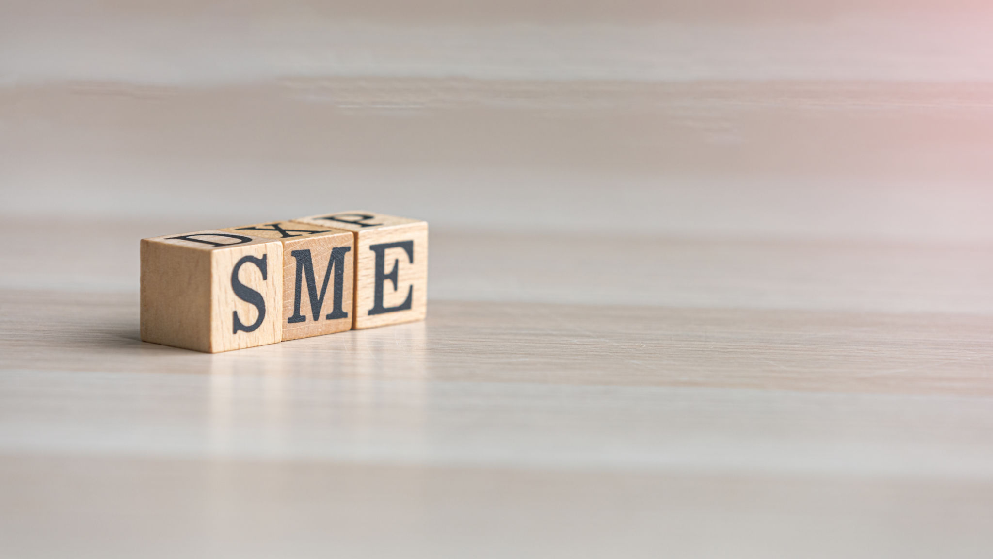 Wooden blocks of SME representing Small Medium Enterprise on a business table